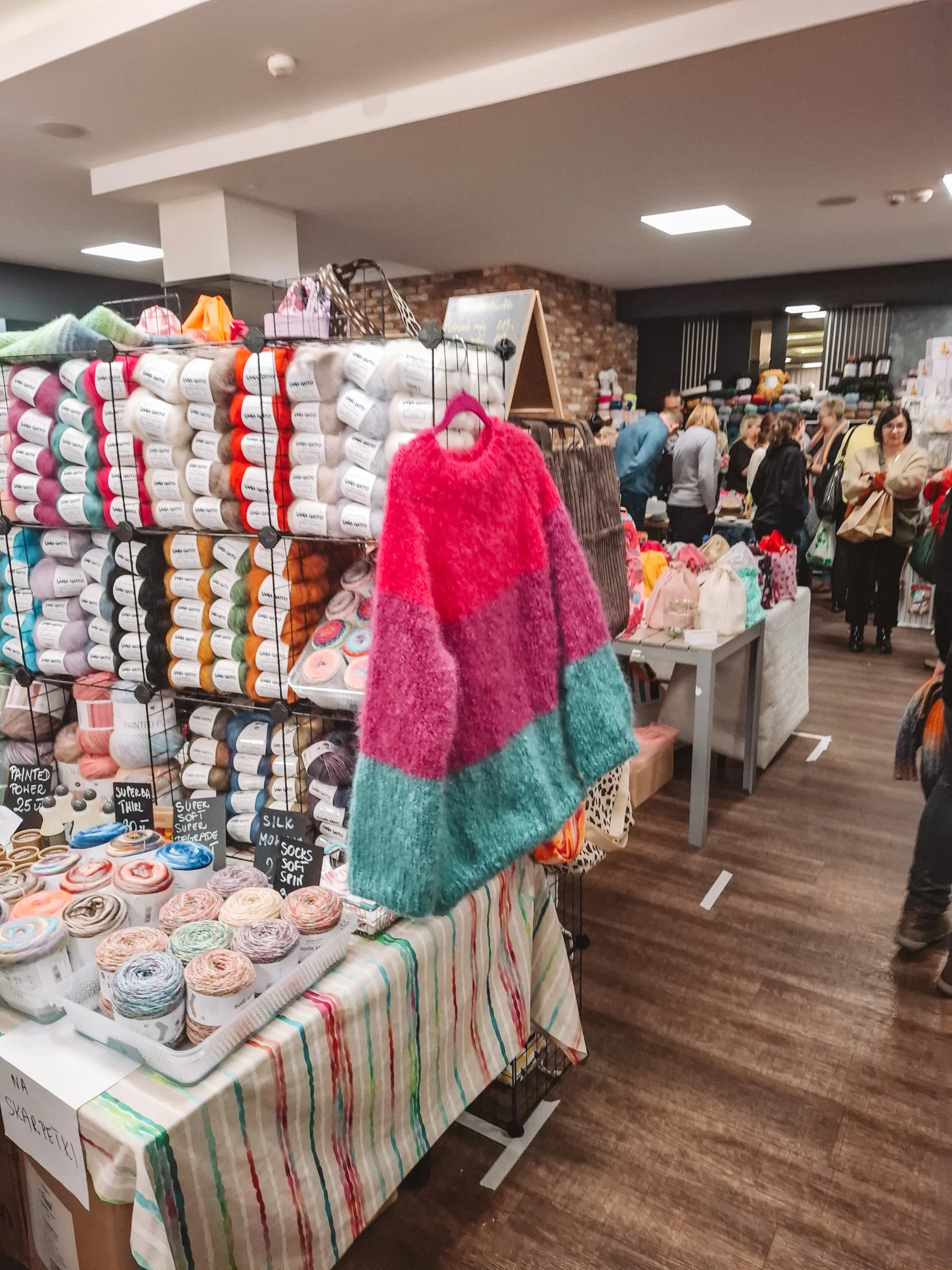 Widok na targi "Zamotka" 2025 w Częstochowie – kolorowe stoiska z włóczkami, szydełkami i akcesoriami dziewiarskimi.